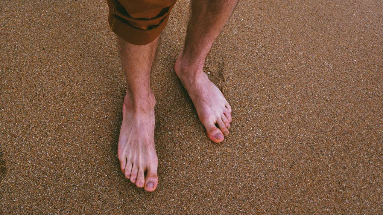 Bare feet shown on a tiled floor.