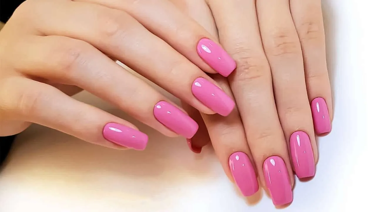 Hands with bright pink gel nails.