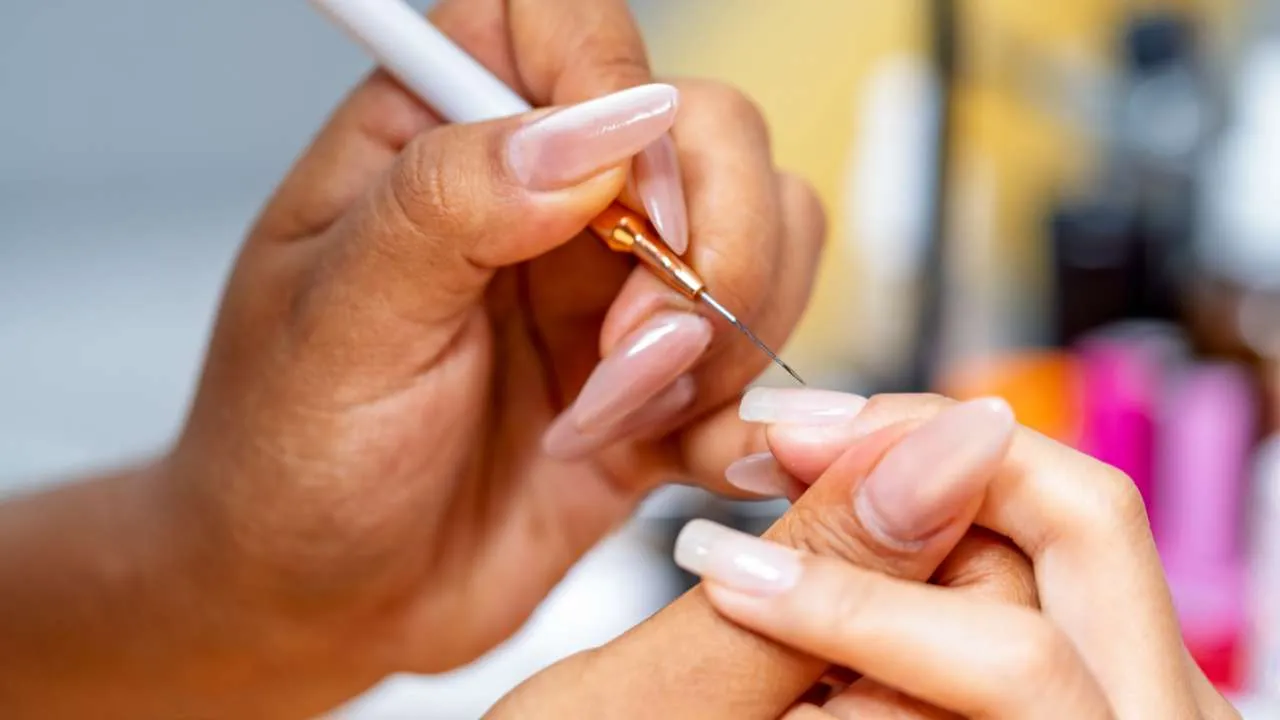 Nail technician fitting a gel extension.