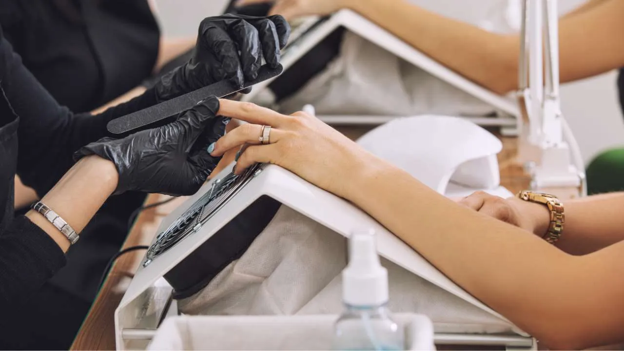 Manicure in progress with nail tools nearby.